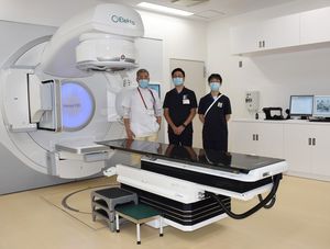 八戸赤十字病院が新たに導入した放射線治療装置を紹介する田口副院長・放射線科部長（左）ら
