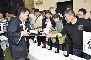 会場を回り約70種類の日本酒を飲み比べる参加者たち