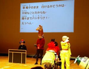 「しょうがい」や人権をテーマにした演劇の一場面。車いすに乗った赤いバラの役で出演した三井絹子さん（右から２人目）＝東京都国立市のくにたち市民芸術小ホール