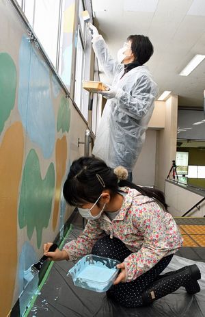青森駅舎の壁をペンキで彩る造形教室の生徒ら
