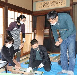 修学旅行で五ろりを訪れ、竹細工に挑戦する地元の小学生。斉藤明さん（右）が、妻の三千代さん（左から2人目）と二人三脚で運営する＝2021年11月、新潟県五泉市