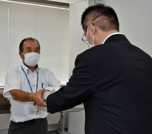 和嶋教育長（右）に署名を手渡す「浪岡高校の存続を求める会」の関係者