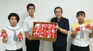 大嶋理事長（右から2人目）に手作りの金魚ねぶたを手渡す、おもてなしボランティア隊の代表生徒