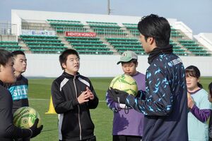 サッカー教室で金井さん（手前右）の指導を受ける参加者たち＝八戸市のプライフーズスタジアム（ヴァンラーレ八戸提供）