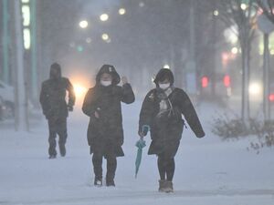吹雪の中、寒さをこらえながら家路へ急ぐ高校生ら＝13日午後4時17分、青森市東大野1丁目