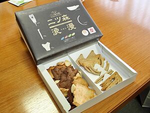 二ツ森貝塚の出土品を模したクッキーの第2弾「二ツ森浪漫」＝七戸町役場提供（撮影用にクッキーを袋から取り出しています）