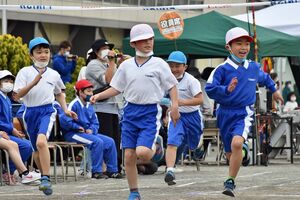 マスクを外して徒競走に臨み、ゴールで笑顔を見せる児童＝22日午前、青森市の大野小学校
