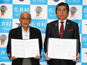協定書を交わした磯川代表取締役（左）と樋口村長