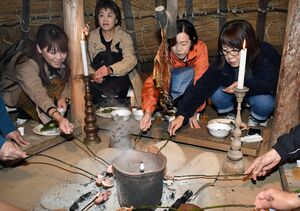 竪穴住居の中で縄文食を味わうツアー参加者