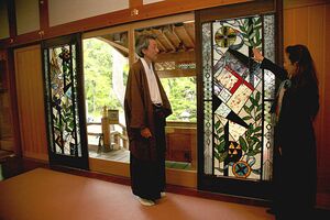 拝殿に設置した大型のステンドグラスの図柄について、高橋さん（右）の説明を受ける禰宜の山崎さん