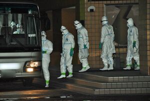 殺処分のため、防護服に着替えてバスに乗り込む県職員たち＝15日午後7時半ごろ、横浜町トレーニングセンター