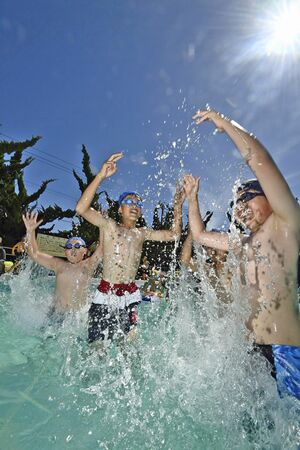 真夏のような暑さの中、水しぶきを上げてプール遊びをする子どもたち＝3日午後、青森市松原の青森勤労者プール
