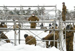 大雪像制作のため、足場の点検や除雪をする自衛隊員