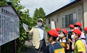 大瀧会長（左）から、地域に伝わる民話や伝説について学ぶ新井田小の児童たち