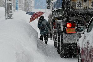 歩道が雪でふさがっているため車道を歩く歩行者＝28日午前7時56分、青森市堤町2丁目