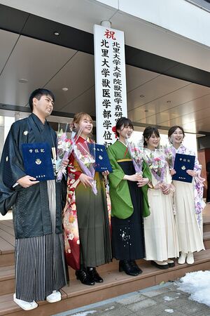 学位記を手に記念写真に納まる卒業生たち＝10日、十和田市の北里大学獣医学部キャンパス