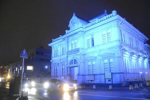 青いライトに照らされて闇の中に浮かび上がった弘前市の旧第五十九銀行本店本館＝1日午後5時55分ごろ