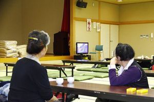 平川市が開設した自主避難所に来てテレビのニュースを見守る市民＝6日午後4時40分、平川市健康センター
