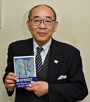 新刊「八甲田雪中行軍　一二〇年目の真実」を手にする間山さん