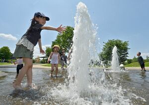 噴水のある水場で、歓声を上げながら水遊びを楽しむ子どもたち＝18日午前、青森市大矢沢のわくわく広場