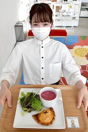 十和田市現代美術館のカフェで新メニューのビーフパイを手にする秋田店長