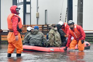 取り残された住民らをゴムボートで救出する消防隊員ら＝3日午前7時30分、三沢市岡三沢8丁目