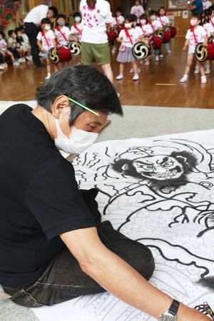 養生幼稚園で46回目のねぷた絵を描く呑龍さん（手前）