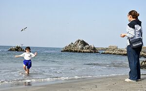 今年初の夏日となった八戸市の海岸では、水遊びを楽しむ親子連れの姿が見られた＝11日午後3時過ぎ、同市鮫町の蕪島海水浴場