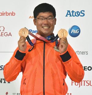 男子個人と団体で勝ち取った二つの銅メダルを手に、満面の笑みを浮かべる古川＝1日、東京都内のホテル