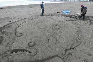 砂で作られた巨大なヒラメ。ご当地グルメ「ヅケ丼」をPRしている