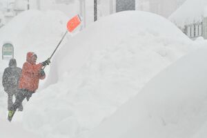 積雪が一時111センチとなった青森市。道路脇にうずたかく積まれた雪山＝28日午前8時54分、同市橋本3丁目