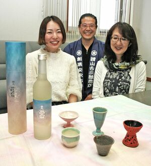 復刻酒「國光正宗」と個性豊かな酒杯、風呂敷を前にする布施さん夫妻と安藤さん（左）