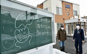 藤田所長（右）手書きの掲示板。立ち止まって見る地域住民が増えて好評という