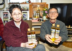 菜種油の完成を喜ぶ山端さん（右）と妻サチエさん。背後の仏壇にも菜種油を供えている