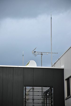 鯵ケ沢町役場庁舎にテレビアンテナとともに立つ2本の避雷針。どちらかに落雷したとみられる＝22日