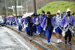 雨の中、五戸高校に向けて歩き続ける生徒と先生たち