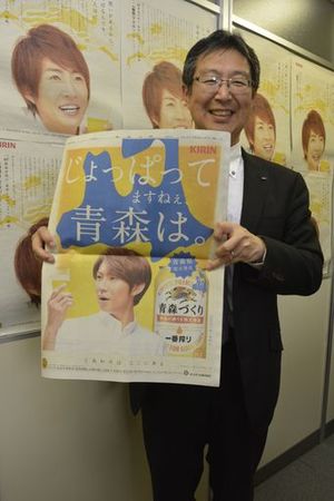 相葉さんが「一番搾り　青森づくり」をＰＲした７日付東奥日報朝刊の全面広告を持つ松崎支社長