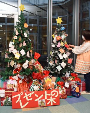 子どもたちの欲しい物が書かれたオーナメントが飾られているこどもはっちの「プレゼントの木」。木の周囲には匿名の贈り主から届いたたくさんのプレゼントが並んでいる