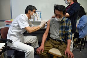 新型コロナウイルスワクチンの2回目接種を受ける高齢者（右）＝3日午後、風間浦村総合福祉センター