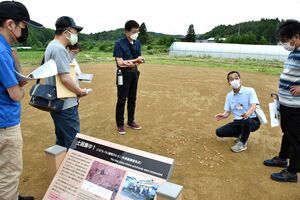 駒田学芸員（右から2人目）の説明を聞く受講者ら＝26日午後、外ケ浜町の大平山元遺跡