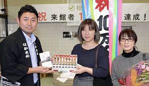 10万人目の来館者となった太田さん（右）と長女の長谷川さん（中）、村上理事長