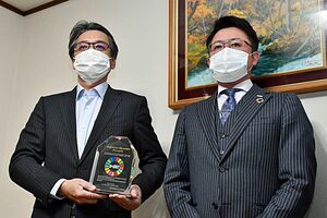 盾を手にする岡村社長（左）と佐藤代表＝7日、青森市のオカムラ食品工業本社