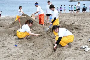 協力して砂の像を制作する学生たち