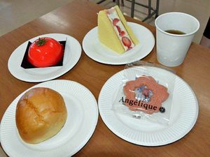 アップルティー（右奥）と、（左奥から時計回りに）トマトジュレのケーキ、イチゴとクリームのサンド、桜の花びらのクッキー、嶽きみのクリームパン