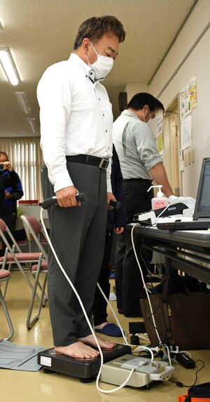 熊谷建設工業で行われた測定会で、体組成計で体重などを測る従業員