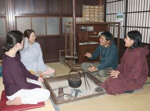 いろりを囲み、昼食に訪れた女性たちと雑談に花を咲かせる場面も＝2021年11月、新潟県五泉市