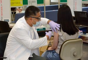 弘大でワクチン接種を受ける弘前医療福祉大の学生（右）＝11日