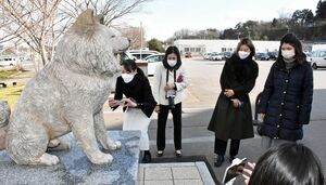 人気犬「わさお」の銅像に見入るツアー参加者