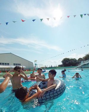 強い日差しの下、プールで遊ぶ子どもたち＝2日午後2時半ごろ、弘前市八幡町1丁目の城北ファミリープール