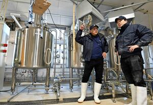 タンクが並ぶ醸造所で、坂本さん（右）と一つ一つ確認し合いながら仕込み作業を進める山形さん＝2021年12月、八戸市